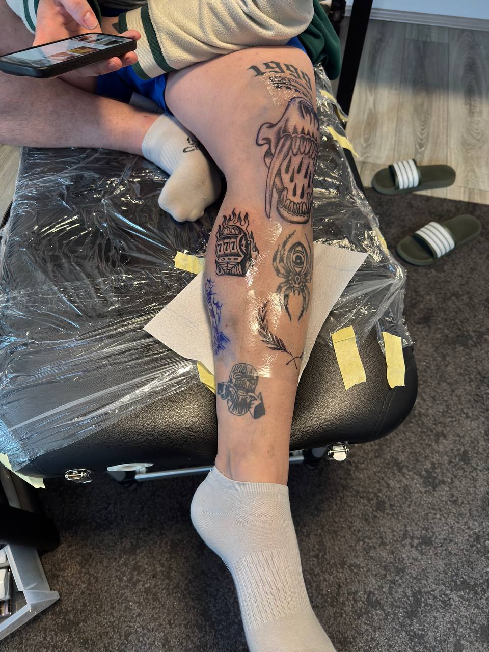 Tattoo-Collage mit Skull, Spider und kleinen Motiven am Bein